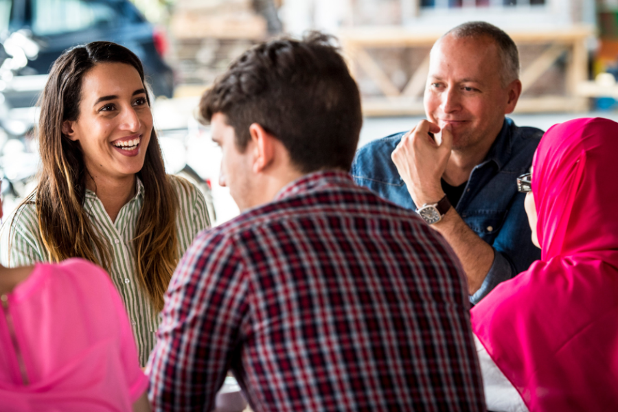 Diverse mensen praten in een cirkel aan tafel